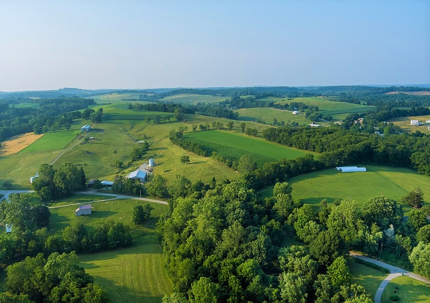 An aerial view of rural farmland under a blue sky.